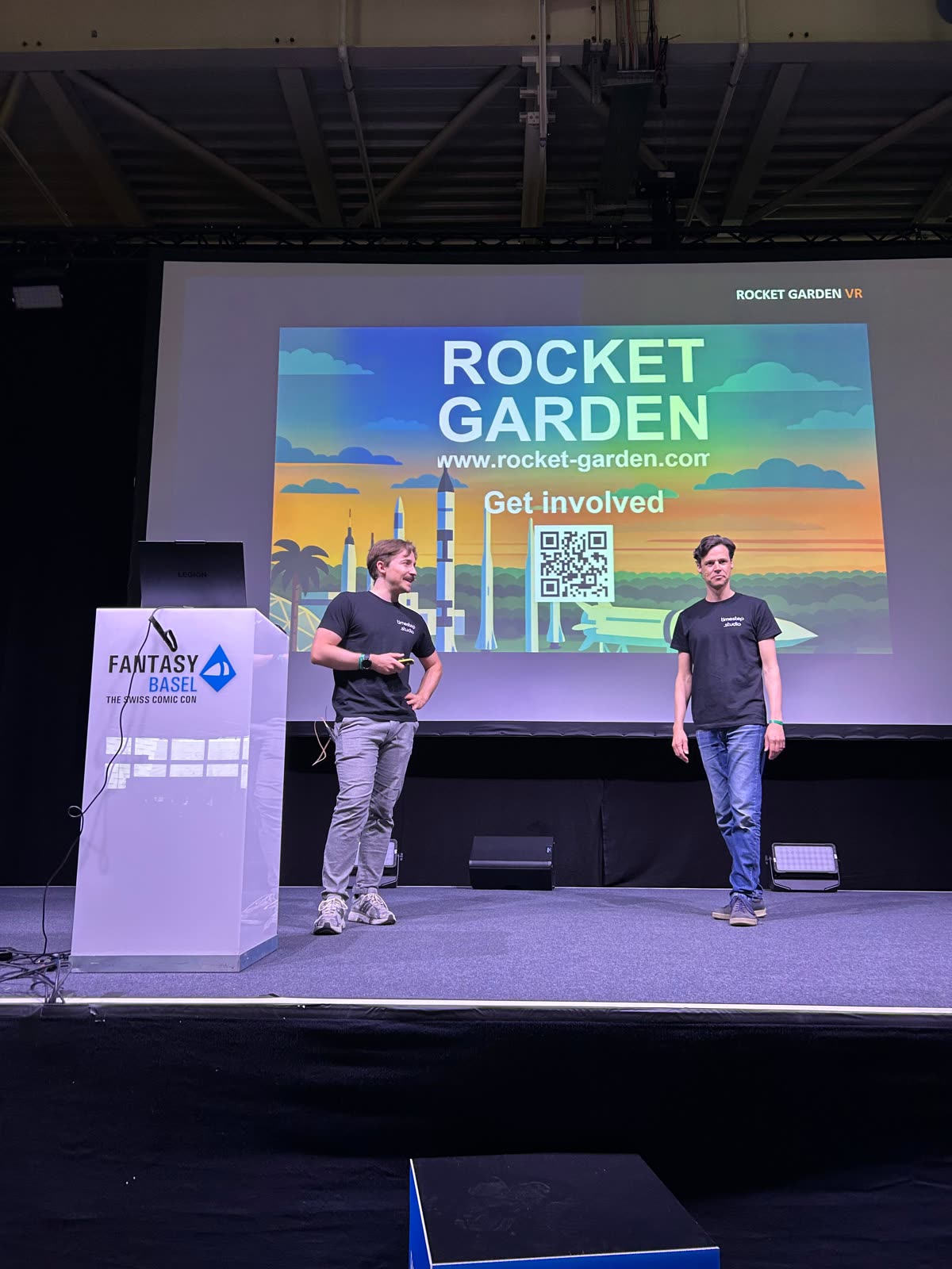 Two speakers from Timestep Studio on the Fantasy Basel stage in front of the Rocket Garden slide